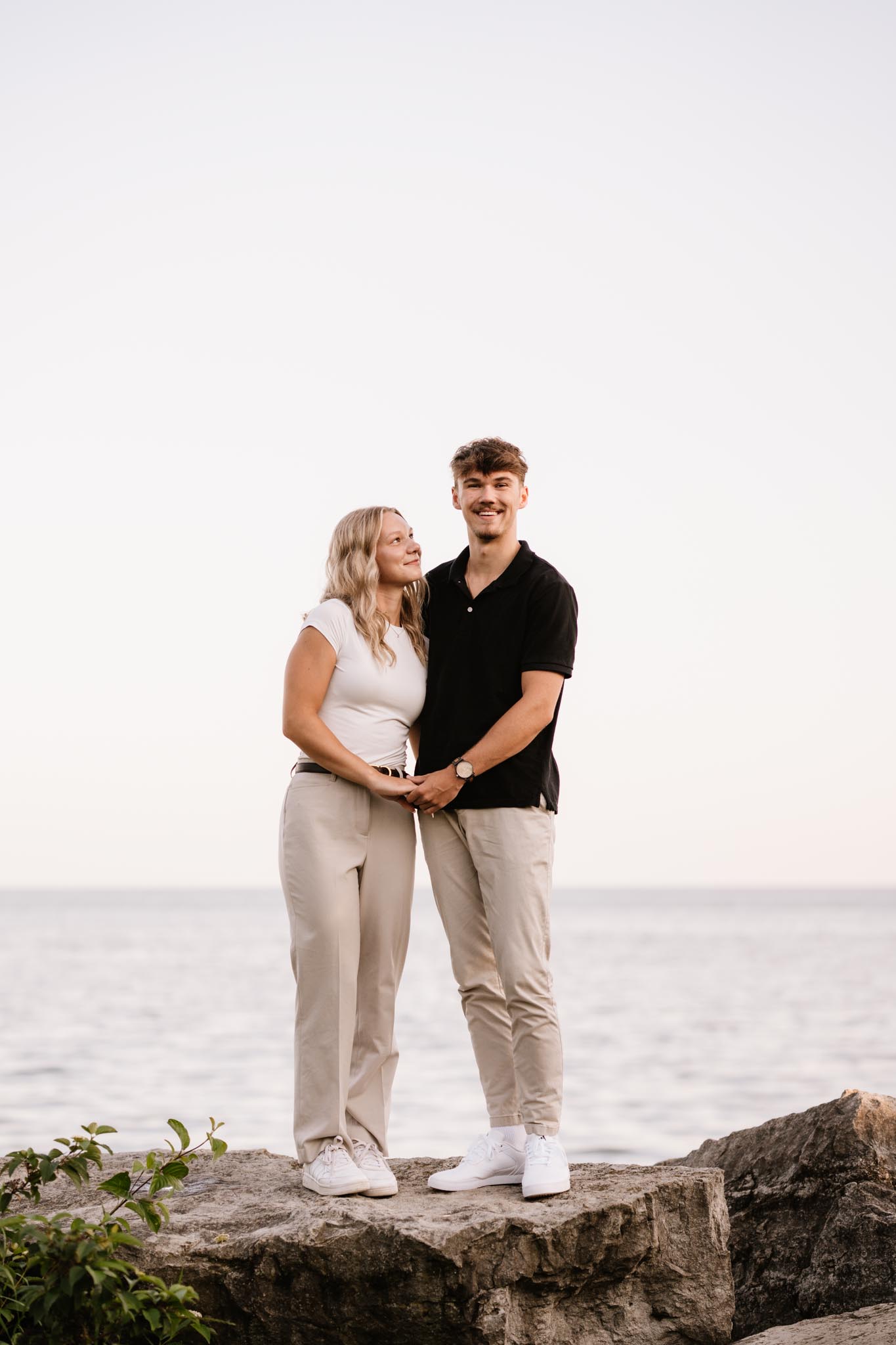 A young couple embracing and smiling in Humber Bay Park West, Toronto.