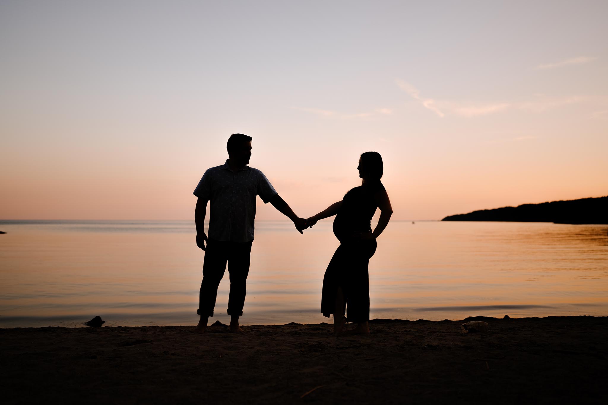 A Pregnant couple silhouette at sunset at Scarborough Bluffs Beach